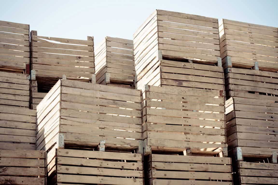 A stacked arrangement of wooden crates under a clear blue sky.